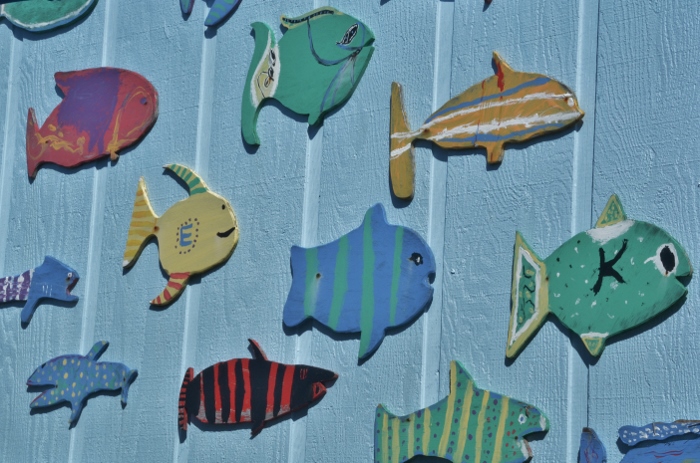 colorful wooden fishes decorate outside wall of eatery